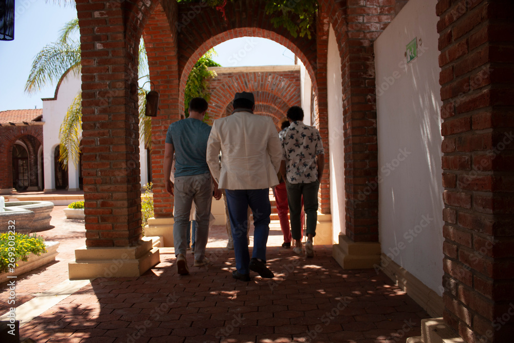 People walking among arches and columns of red bricks in the outskirts of the city of Baja California Mexico