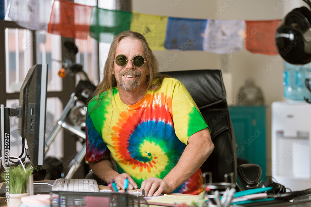 Smiling Man with Round Glasses in a Colorful Office Smiling Man with Round Glasses in a Colorful Office