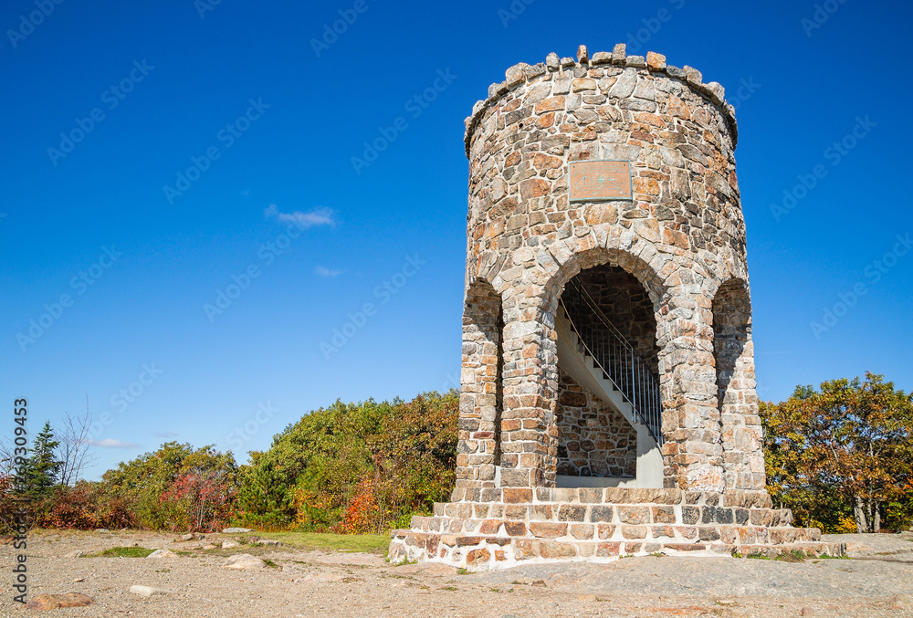 Observation tower at the peak of Mount Battie in Camden, Maine, USA. Sunny, autumn day with bright blue sky background. Observation tower at the peak of Mount Battie in Camden, Maine, USA. Sunny, autumn day with bright blue sky background.