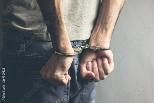 young man hand handcuffs on dark background © S...