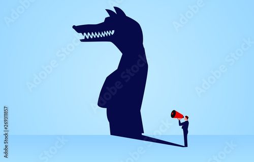 The shadow of a businessman holding a megaphone standing and shouting is a wolf