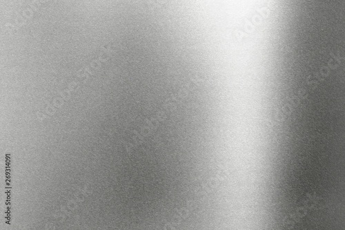 Light shining on rough gray metal wall, abstract texture background