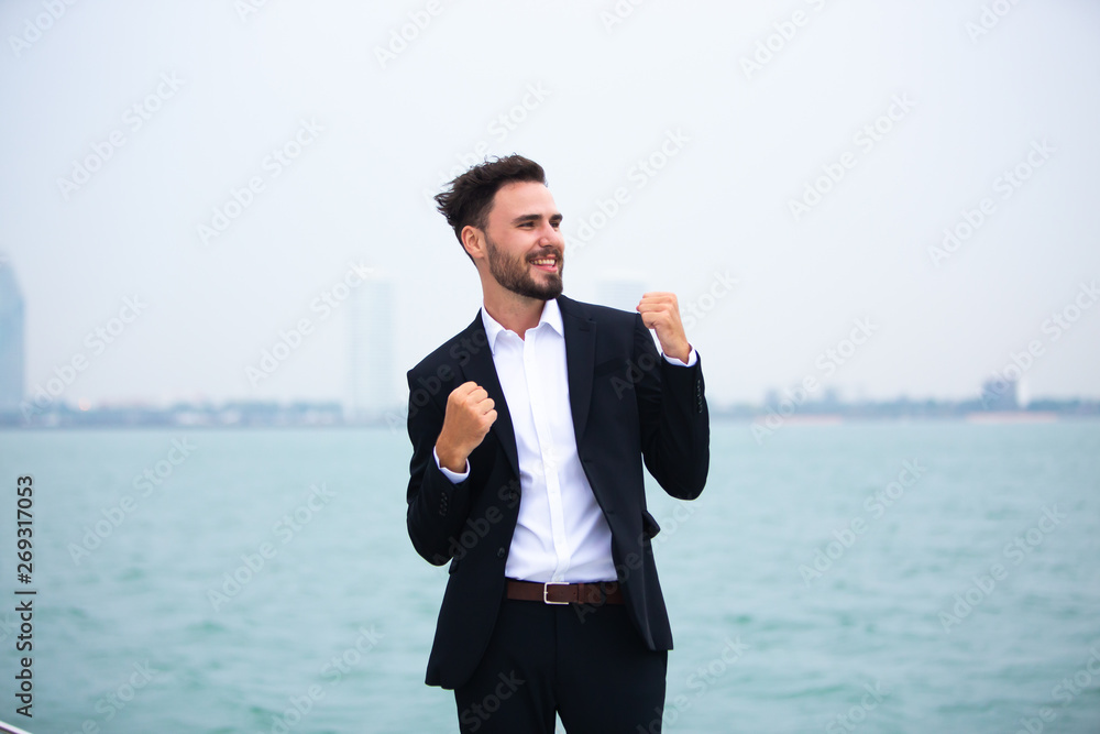 Portrait of a positive young businessman feeling very happy on the vacation sailboat yacht standing on a deck Portrait of a positive young businessman feeling very happy on the vacation sailboat yacht standing on a deck