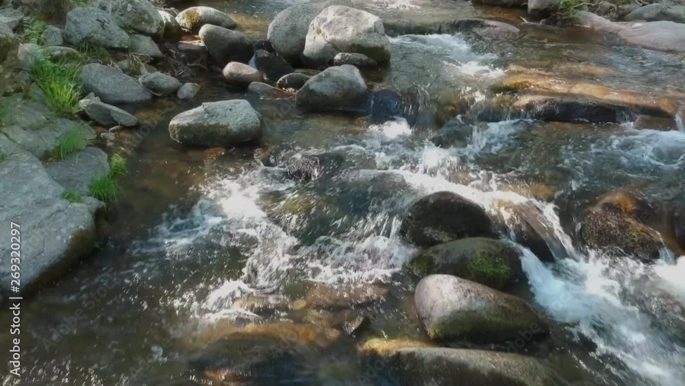 A close shot near the surface going up a river plenty of rocks. A close shot near the surface going up a river plenty of rocks.