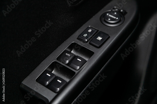 Сlose-up of the car  black interior:  the side door buttons: window adjustment buttons, door lock and other buttons. © Виталий Сова