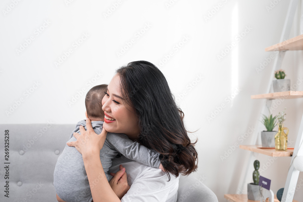 happy family at home. Mother holding baby daughter in living room in cozy weekend morning happy family at home. Mother holding baby daughter in living room in cozy weekend morning