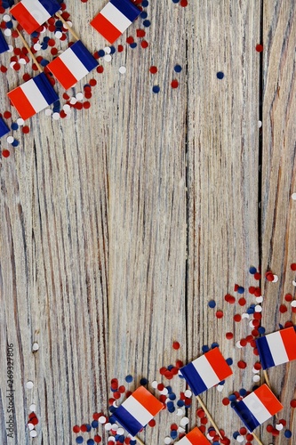 Slika na platnu The national holiday of July 14 is a happy Independence Day of France, Bastille Day, the concept of patriotism, memory, place for text, confetti and flags on a wooden table