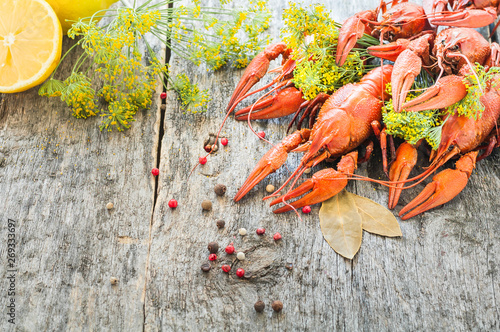 Boiled crawfish with lemon and dill on a wooden background