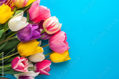 Fototapeta Naklejka Na Ścianę i Meble -  bright spring bouquet of multi-colored tulips on a blue background
