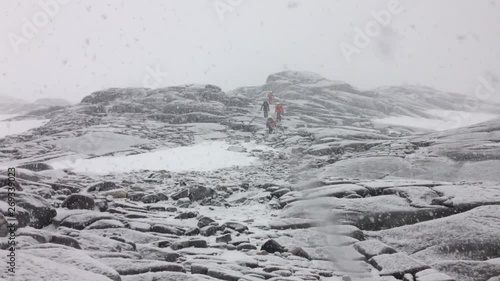 snowfall in Antarctica, group of tourist hiking on Pleneau island photo