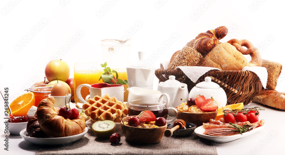 Huge healthy breakfast on table with coffee, orange juice, fruits, waffles and croissants. Good morning concept. Huge healthy breakfast on table with coffee, orange juice, fruits, waffles and croissants. Good morning concept.