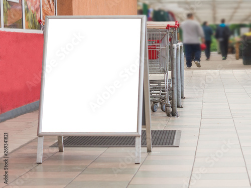 Blank billboard in a supermarket, next to shopping carts