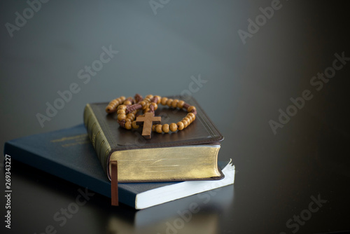 Holy bible book and wooden cross on black desk in church,prepare to study bible in christian religion.