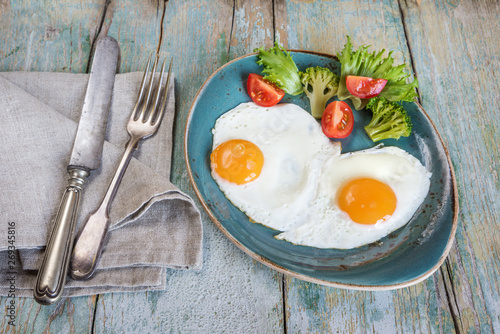 Two fried eggs and vegetables