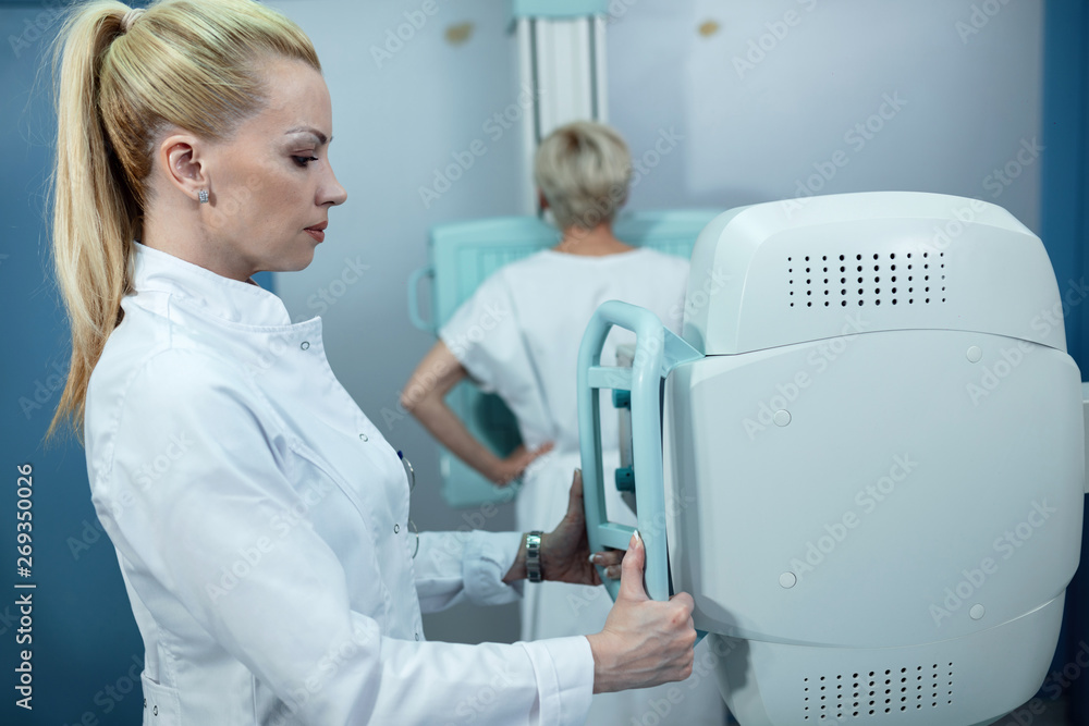 Nurse monitoring X-ray procedure of a patient in the hospital. Nurse monitoring X-ray procedure of a patient in the hospital.