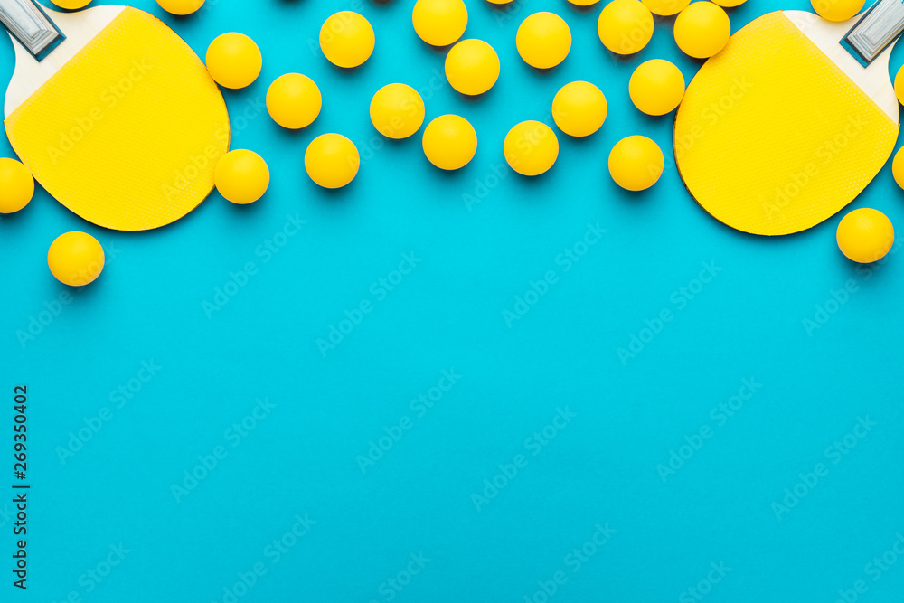 two rackets and many balls for table tennis on turquoise blue background. flat lay image of many table tennis balls and paddles. minimalist photo of yellow ping-pong equipment with copy space