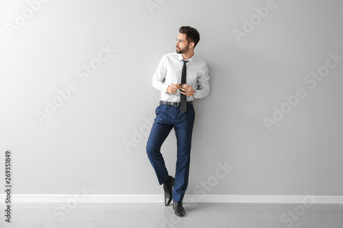Quadro em tela Fashionable young man near grey wall