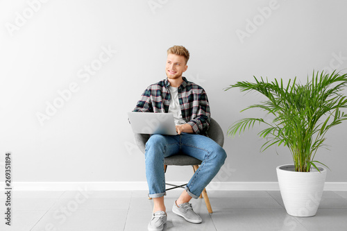 Handsome young man with lap...