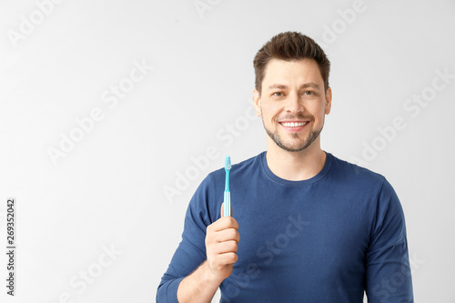 Man with toothbrush on ligh...