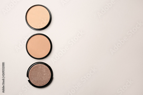 Different facial powder on light background