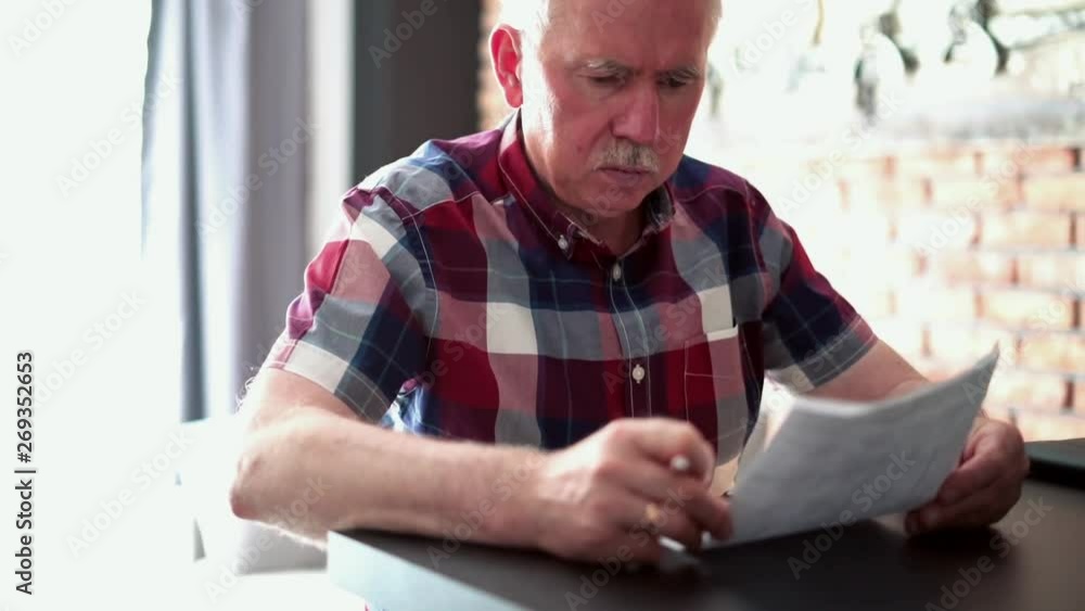 Sad, senior man reading bills at home Sad, senior man reading bills at home