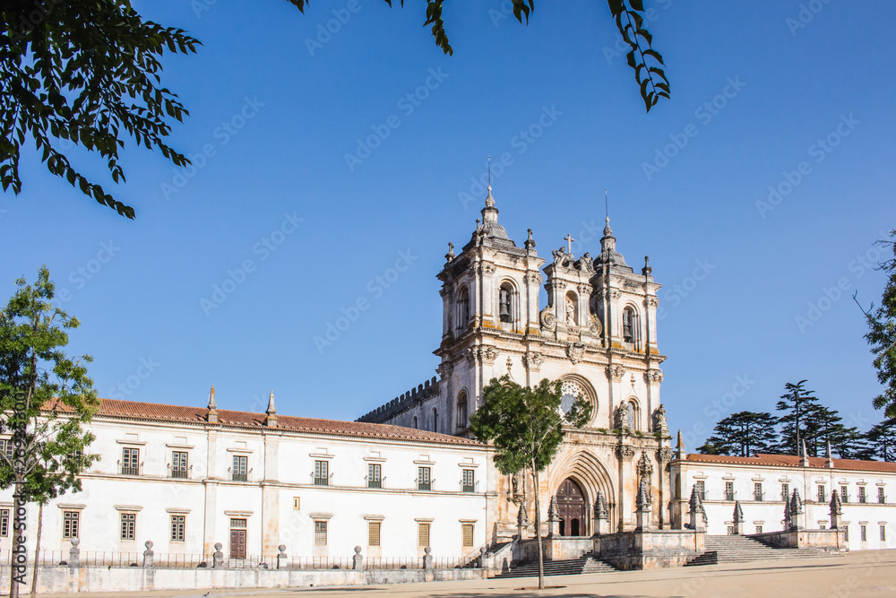 Full view of the beautiful Roman Catholic Alcobaca Monastery during the day with clear blue sky.
