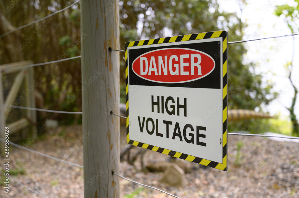Fototapeta premium Danger high voltage sign on fence