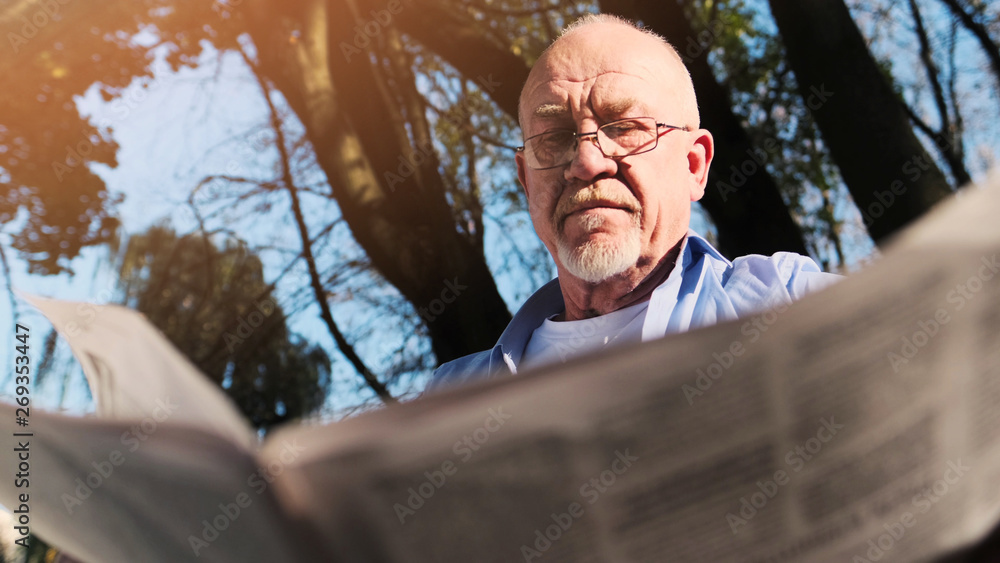 Portrait of senior man with a beard smiling while standing outside in sunlight. Portrait of senior man with a beard smiling while standing outside in sunlight.