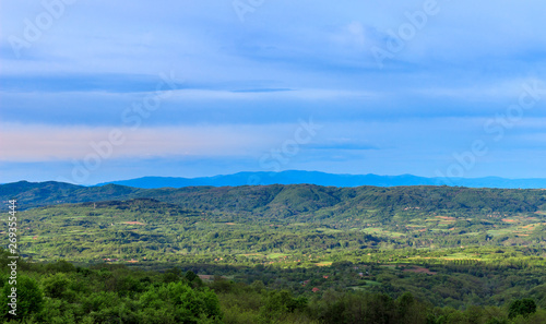 Scenic green valley with mountain in the background and blue sky