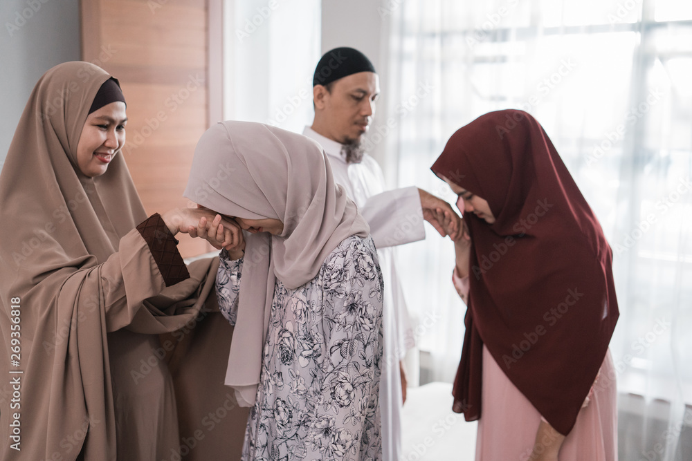 muslim family shake hand apologizing during the Eid mubarak ramadan celebration