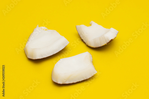 Slices of coconut pulp on a colored background. Refreshing Coconut