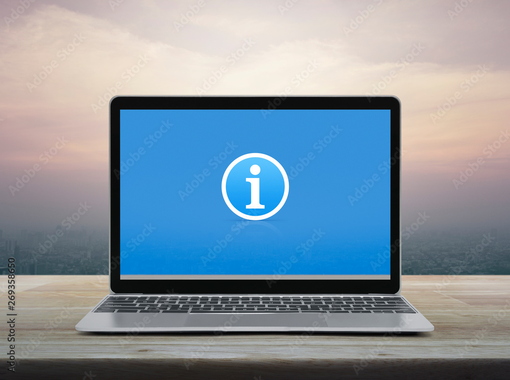 Information sign icon with modern laptop computer on wooden table over office city tower and skyscraper at sunset sky, vintage style, Business customer support online concept Information sign icon with modern laptop computer on wooden table over office city tower and skyscraper at sunset sky, vintage style, Business customer support online concept