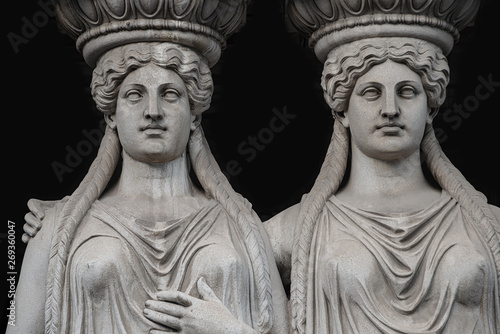 Statue of two sensual Roman renaissance era women at Parliament building in Vienna, Austria, isolated at black background