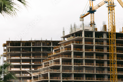 construction yellow crane and building construction site against sky