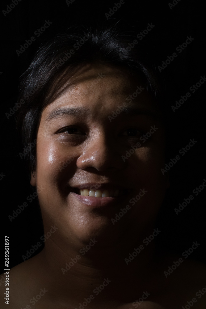 Portrait of a man smiling with in studio black background Portrait of a man smiling with in studio black background