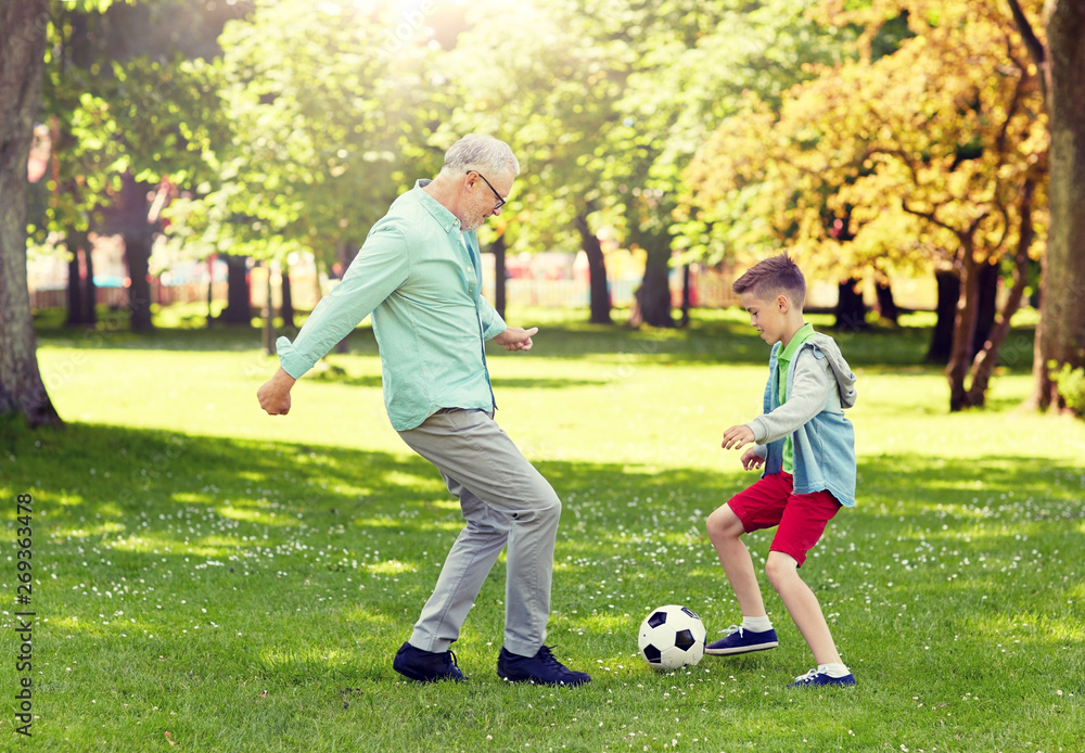 family, generation, game, sport and people concept - happy grandfather and grandson playing football at summer park - obrazy, fototapety, plakaty 