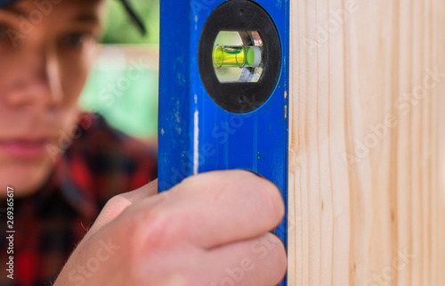 Young handsome man using spirit level in his work photo