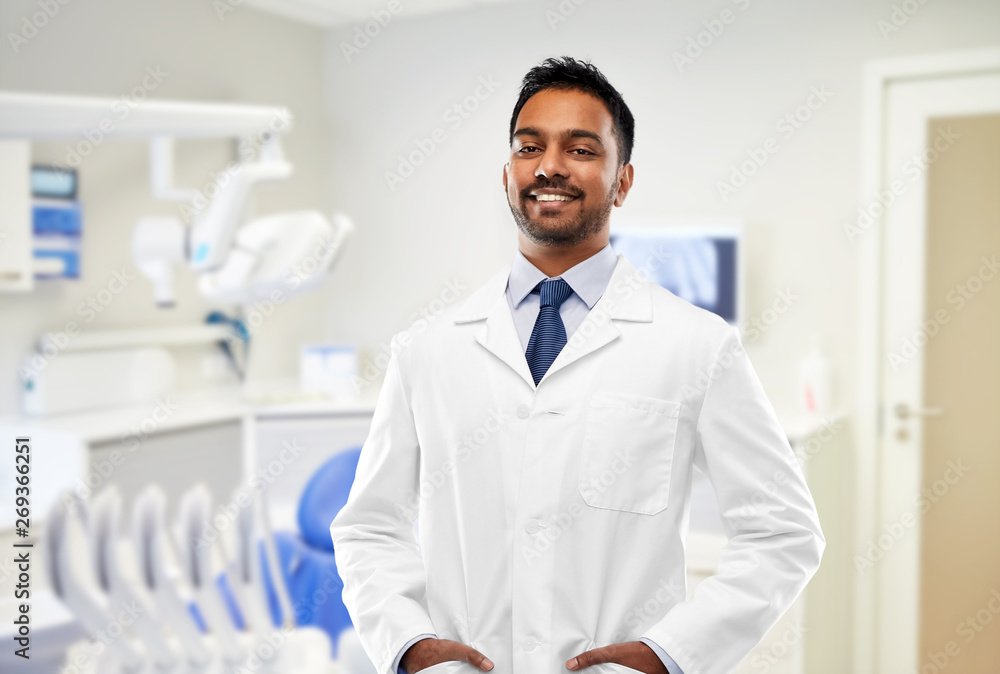 medicine, dentistry and profession concept smiling indian male dentist in white coat over
