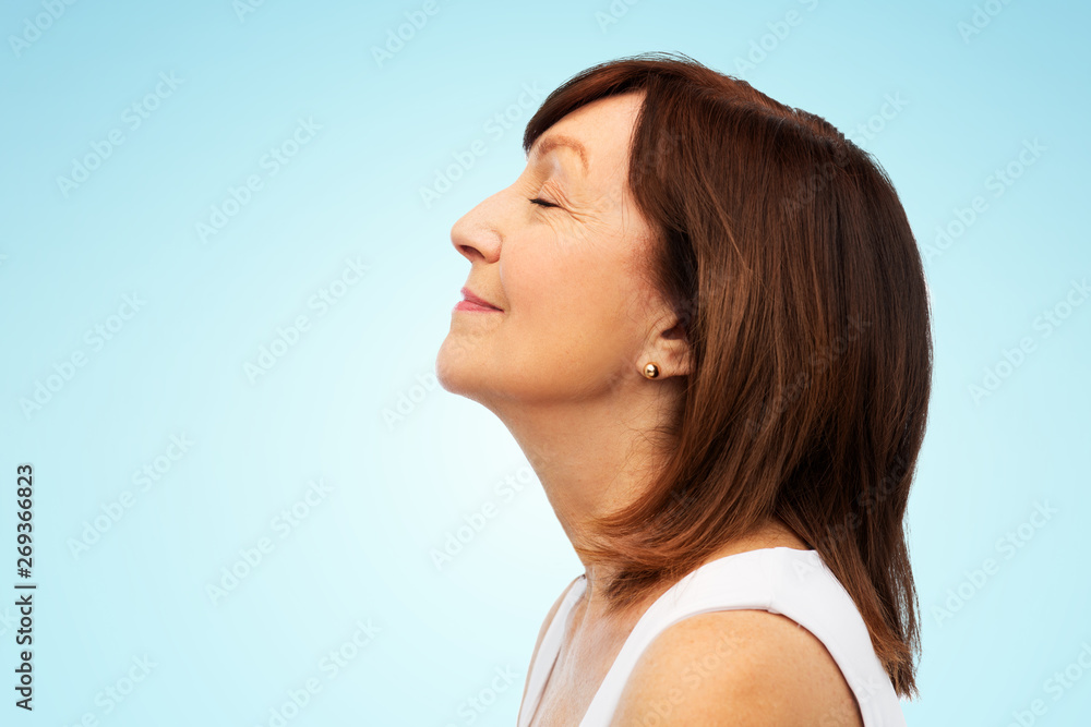 beauty, rhinoplasty and old people concept - profile of smiling senior woman over blue background beauty, rhinoplasty and old people concept - profile of smiling senior woman over blue background
