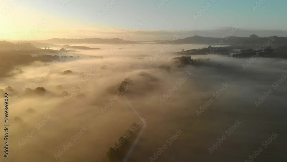 Aerial drone bird's eye shot of a landscape covered in fog and mist during the early hours of sunrise. Aerial drone bird's eye shot of a landscape covered in fog and mist during the early hours of sunrise.
