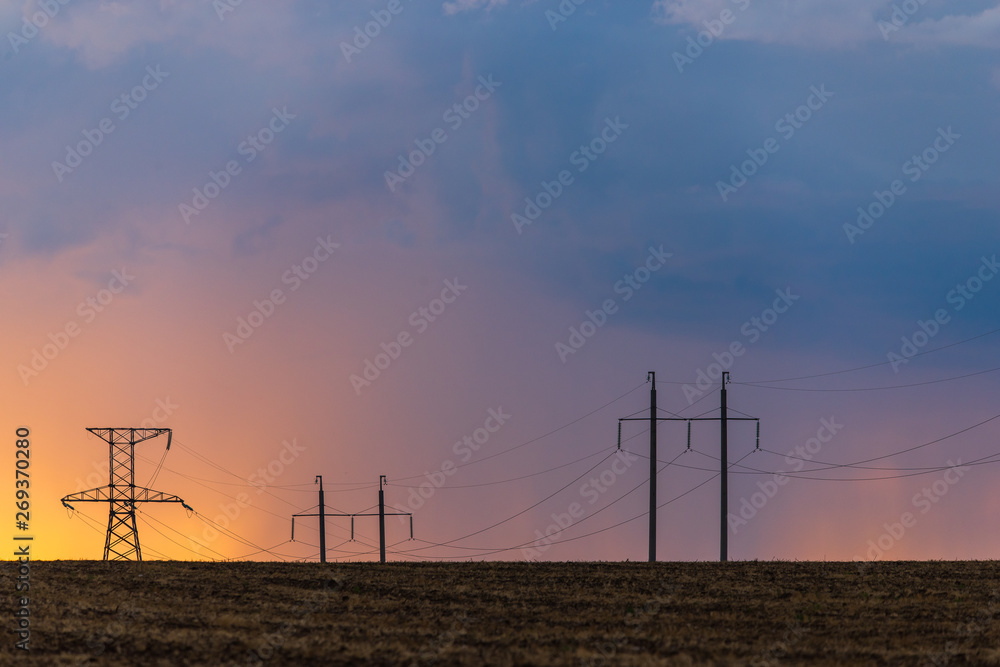 Epic sunset with rural landscape with high-voltage line