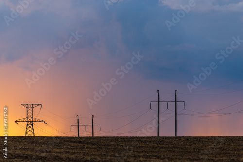 Obraz na płótnie Epic sunset with rural landscape with high-voltage line w salonie
