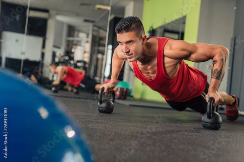 Fototapeta Naklejka Na Ścianę i Meble -  Young muscular man in the gym doing exercise