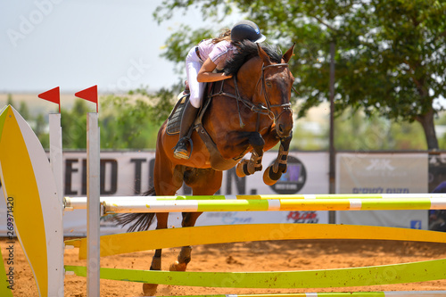 Young rider jumping over the obstacles during the horse jumping competition © PROMA