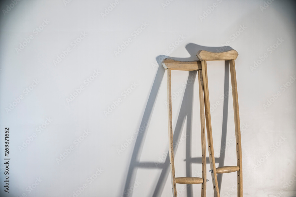 crutches stand at the light wall as a symbol of disability and injury crutches stand at the light wall as a symbol of disability and injury