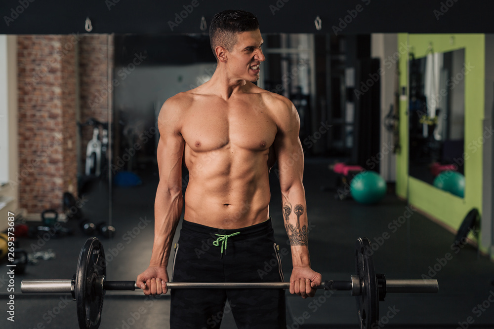 Young muscular man in the gym doing exercise