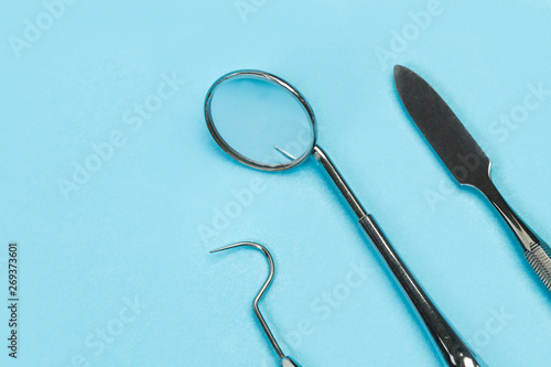 Herramientas e instrumental para dentista odontólogo sobre fondo liso azul. Vista superior. Copy space. Concepto: Salud