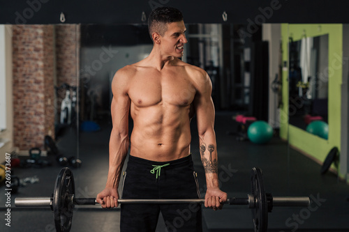 Young muscular man in the gym doing exercise