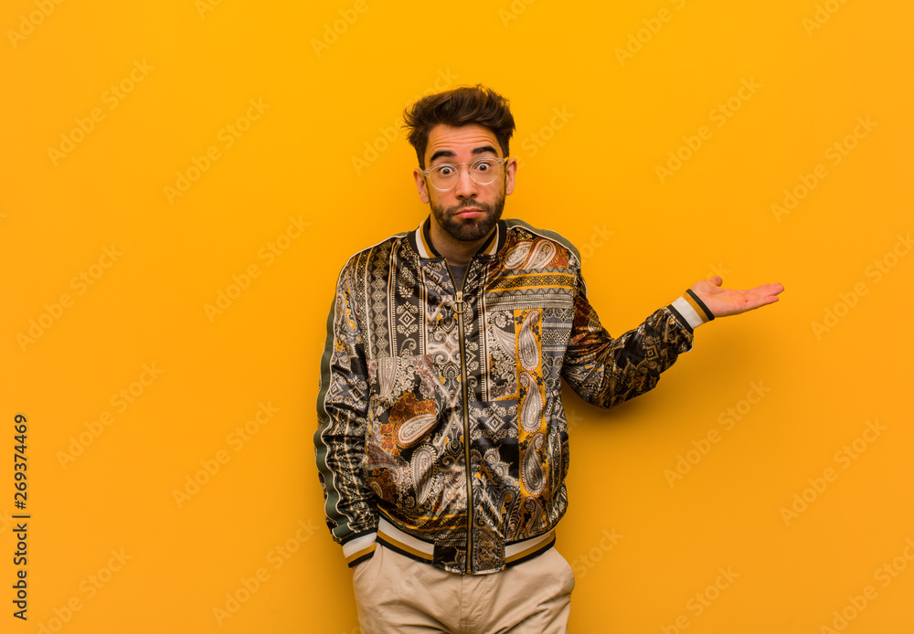 Young cool man doubting and shrugging shoulders Young cool man doubting and shrugging shoulders