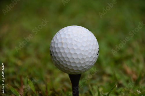 Golf ball on black tee closeup